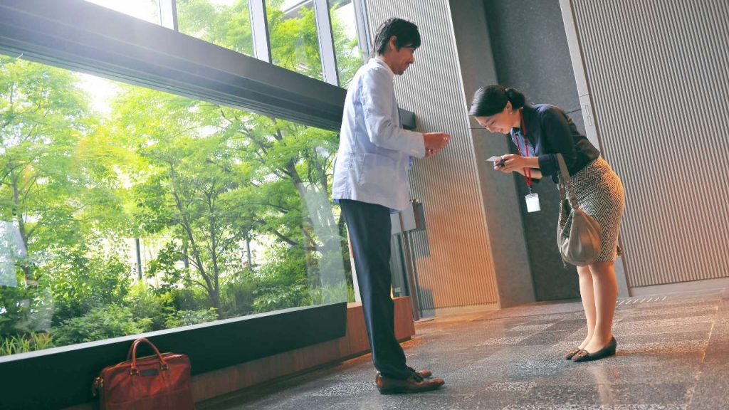 a japanese woman sharing a business card